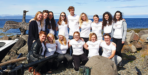 2019 Snorri participants posing by the ocean near the Reykjavík harbour in Iceland. It is a sunny, blue sky day.