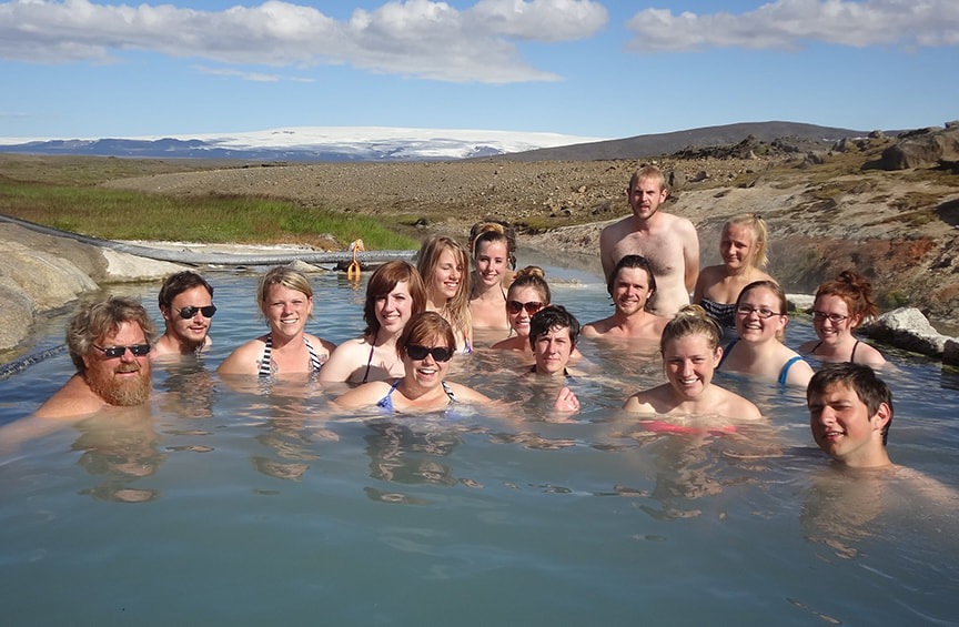 Snorri group sitting in an outdoor hot spring on a sunny day