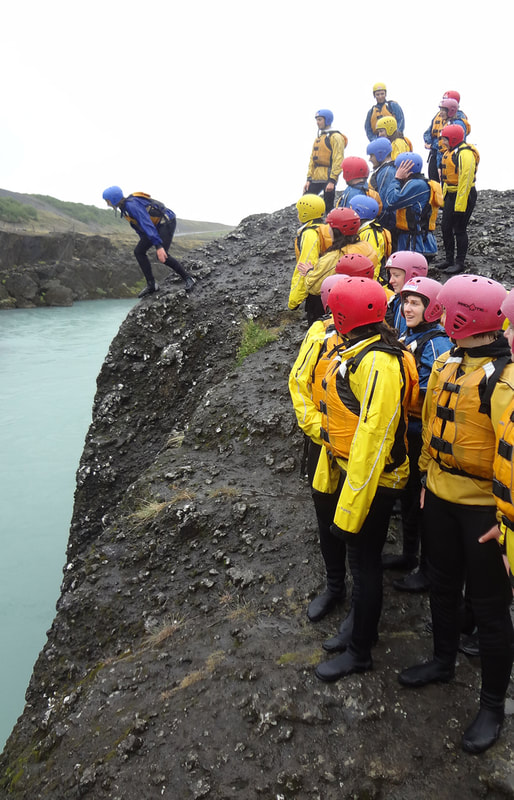 Snorri group jumping off rocks into the river during white water rafting